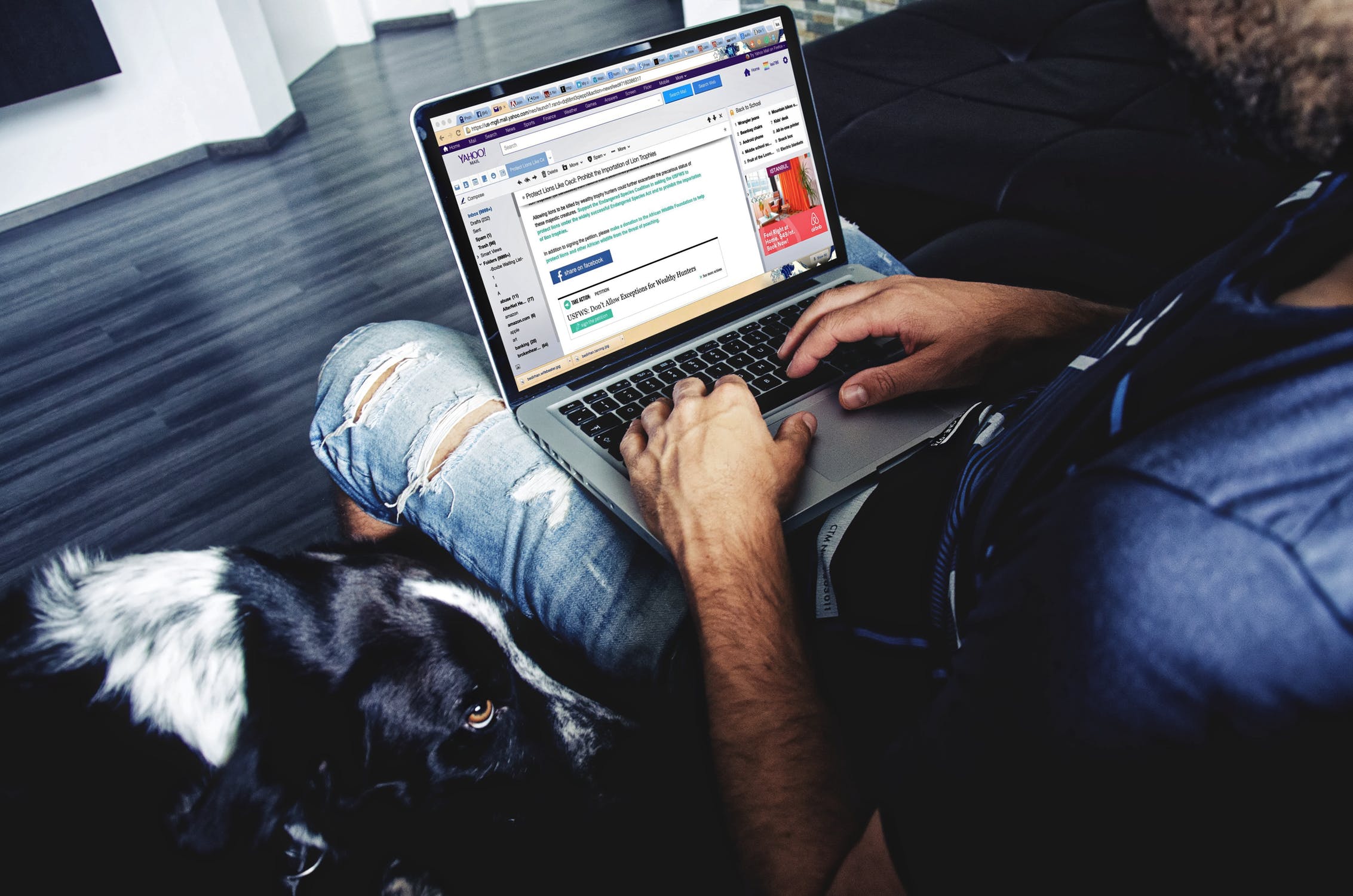 Dog sitting next to man writing an email