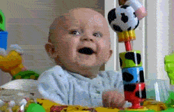 Seated in an activity center, a baby is surprised.