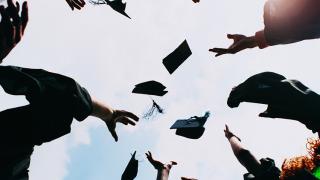 Looking straight up, the sky's the limit as new graduates toss their caps into the air.